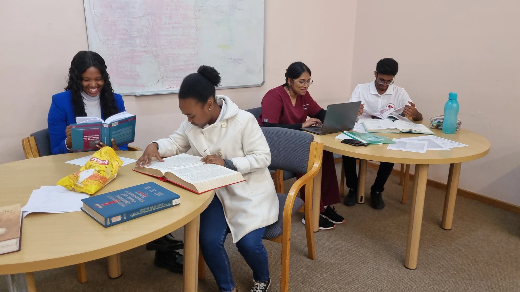 Students attending a study-skills session with textbooks and laptops